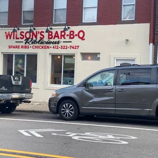 ows two trucks parked in front of a restaurant