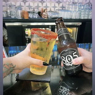 a person holding a beer and a glass