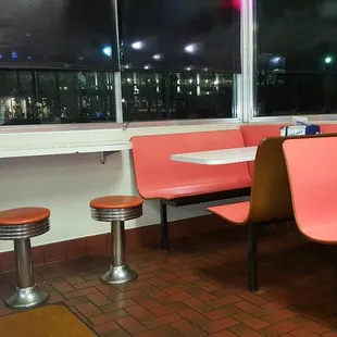 Old school stools and booths with a window view.