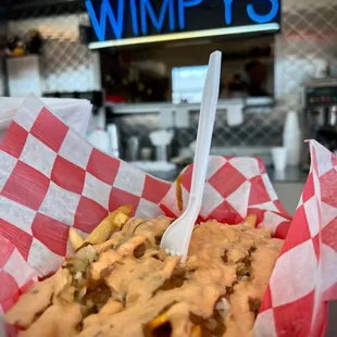 a basket of fries with a fork in it