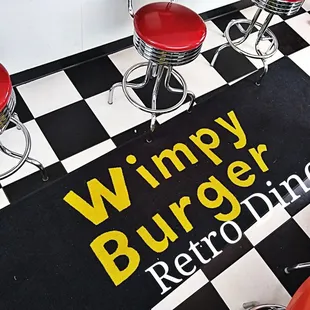 a black and white checkered floor with red stools
