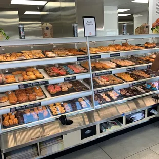 a woman looking at a display of donuts