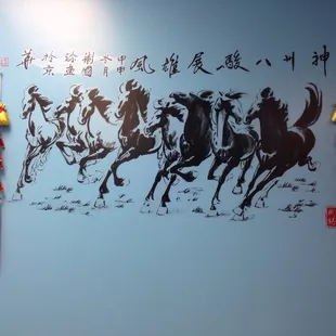 a group of horses running in a line