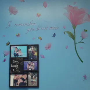 a blue wall with a picture of a pink flower