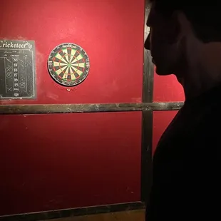 a man standing in front of a dart board