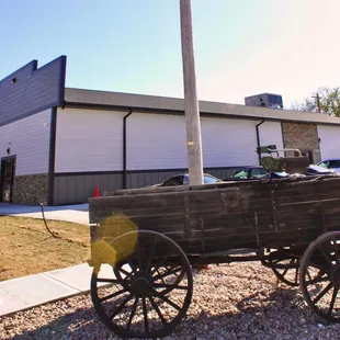 an old wooden wagon in front of a building
