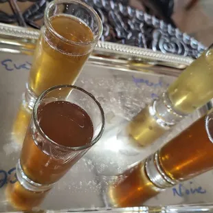 four glasses of beer on a silver tray