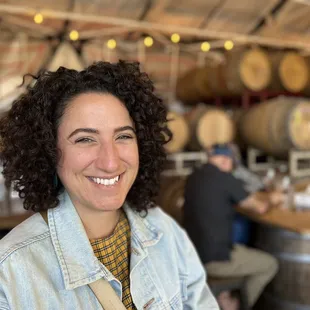 Me enjoying my wine against a backdrop of wine barrels and other people hanging out