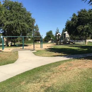 Swingset with the larger playground behind it.