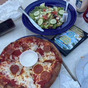 a pizza and a salad on a table