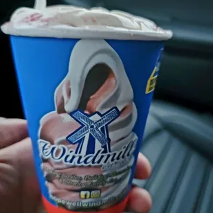 a hand holding a cup of ice cream