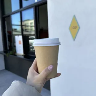 a hand holding a coffee cup