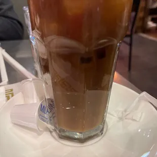 a glass of iced coffee on a plate