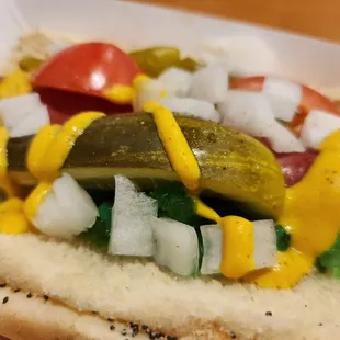 a hot dog with pickles and onions