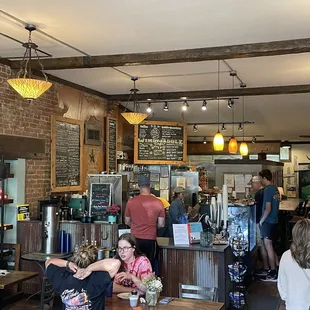 people sitting at tables in a cafe