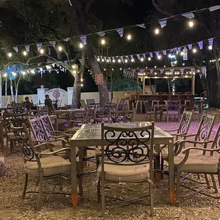 a table and chairs under a string of lights