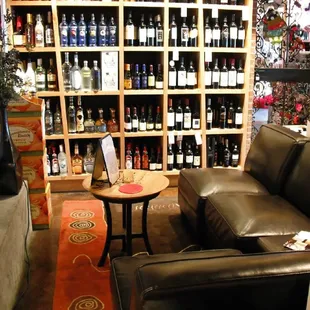 a living room with a fireplace and shelves of wine