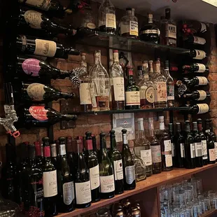 a wall of wine bottles and glasses