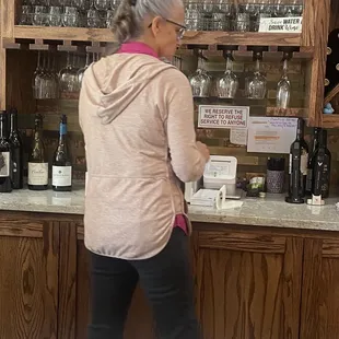 The owner &amp; her bad attitude with a sign saying she will refuse service to I hope she found the stick that was in her butt.