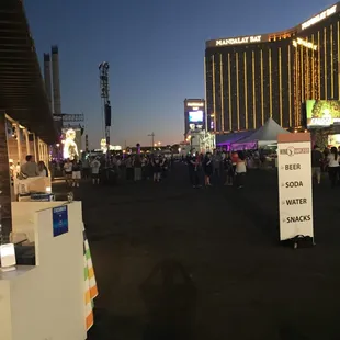 a crowd of people walking down a street at night
