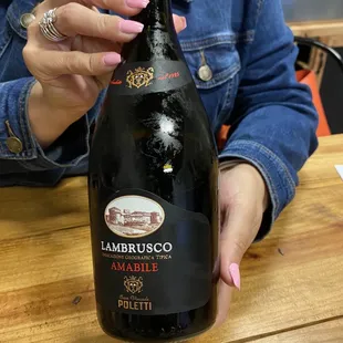 a woman holding a bottle of wine