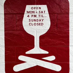 a red and white sign on a brick wall