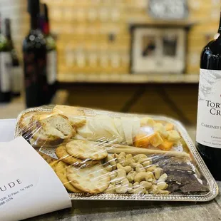 a bottle of wine and a tray of food