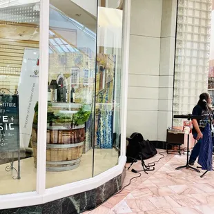 a man playing guitar in front of a store window