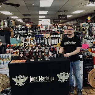 a man standing in front of a wine display