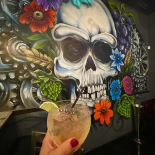 a hand holding a glass with a drink in it