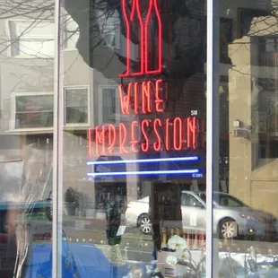 a neon sign in the window of a wine shop