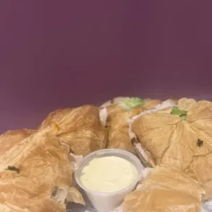 a plate of croissants with dip