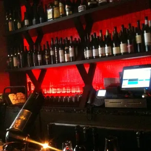 a bar with wine bottles and wine glasses