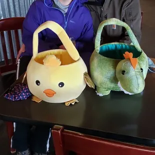 a man and a woman sitting at a table with stuffed animals