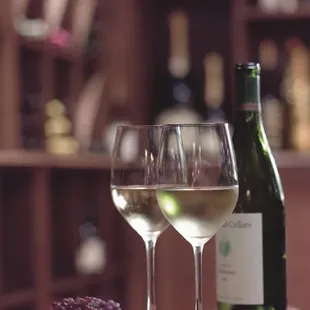 two glasses of wine and a bottle of wine