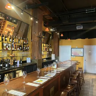 a long bar with wine glasses on it
