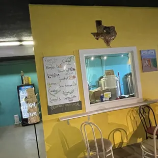 a yellow wall with chairs and a table