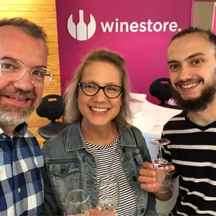 three people holding wine glasses