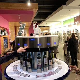 a woman standing in front of a display of wine bottles