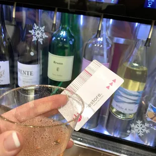 a person holding a wine glass and a ticket