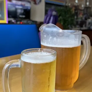 two mugs of beer on a table