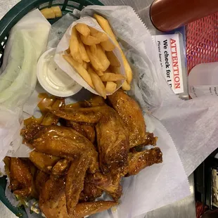 a basket of chicken wings, fries, and ketchup