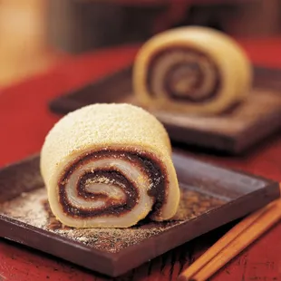 a closeup of a chocolate roll on a plate with chopsticks