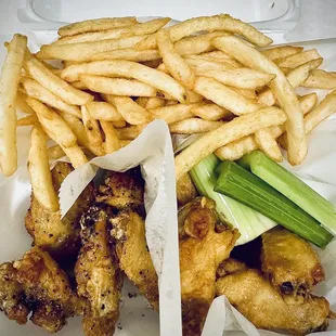 chicken wings and french fries in a styrofoam container