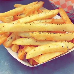 a tray of french fries and a basket of lemon pepper fries
