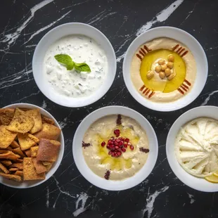 four bowls of dips and crackers
