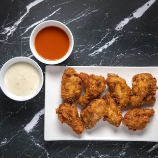 a plate of fried chicken with dipping sauce