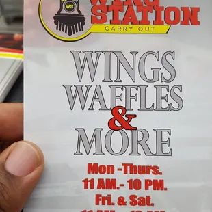 a hand holding a ticket for wings, waffles and more