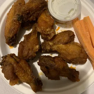 a plate of chicken wings and carrots