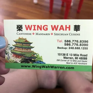 a hand holding a business card